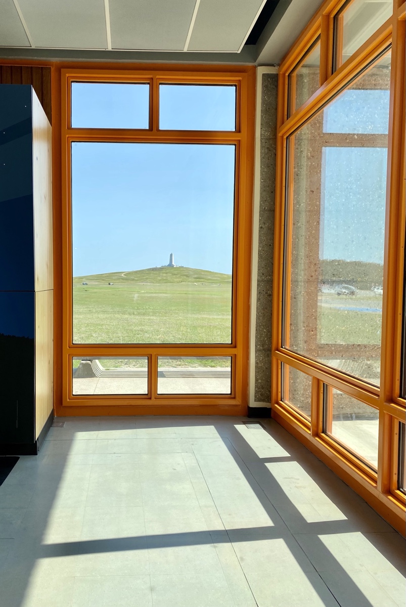 view from the museum lobby of the Wright Brothers Memorial up on the hill