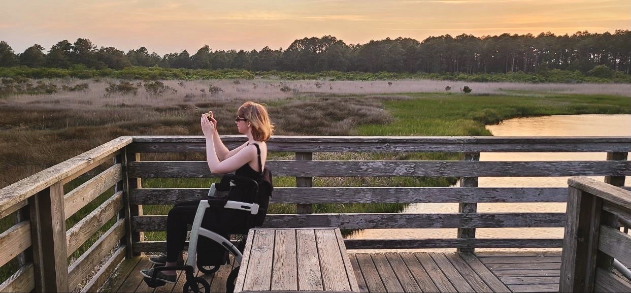 Me photographing the Bodie Island Lighthouse OBX at sunset from my wheelchair