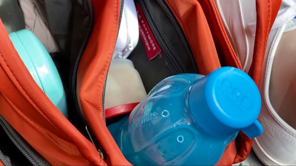 My packmore everyday carry bag with a water bottle and medicine container in it. It’s on the floor of the car cause you can see my white keds shoe to the right. 