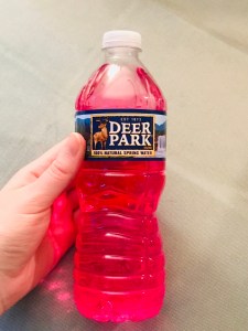 ORS oral rehydration solution in a deer park water bottle; it’s raspberry colored because it’s the raspberry flavor