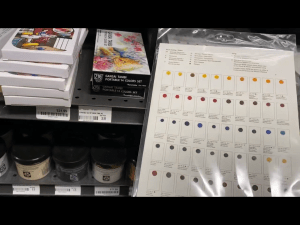 My hand holding watercolor dot cards in Blick Art Materials in DC