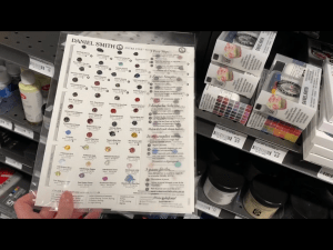 My hand holding Daniel Smith watercolor dot cards in Blick Art Materials in DC