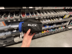 Me holding a Blick pencil case in Blick Art Materials in DC