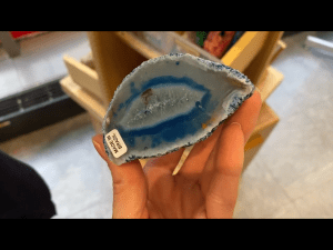 My hand holding a blue agate sparkly rock from Blick Art Materials in DC 