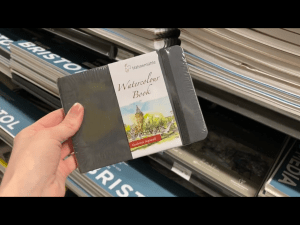 My hand holding the Hahnemuhle book in Blick Art Materials in DC