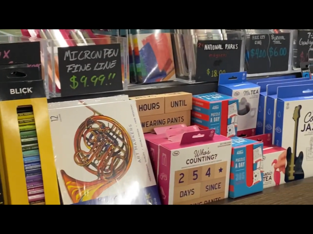 Things at checkout at Blick Art Materials in DC with an “hours til wearing pants” wooden sign in the middle