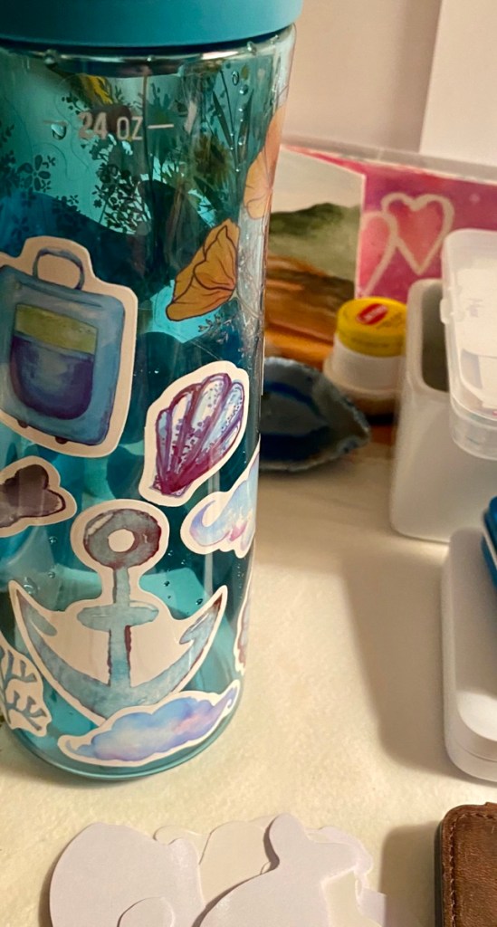 My water bottle on the desk with stickers on it