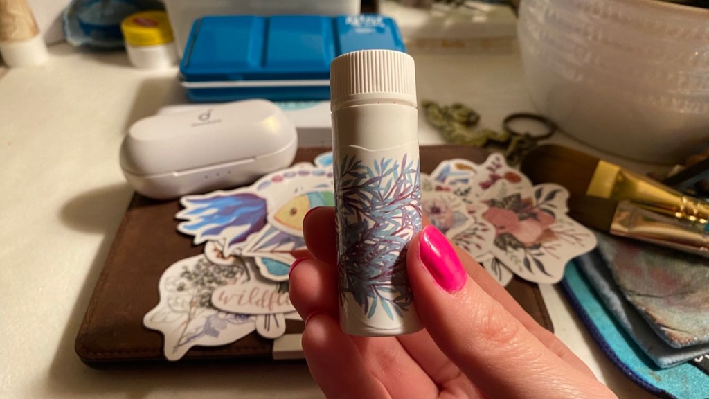 My hand holding the travel prescriptions container with a new sticker on it 